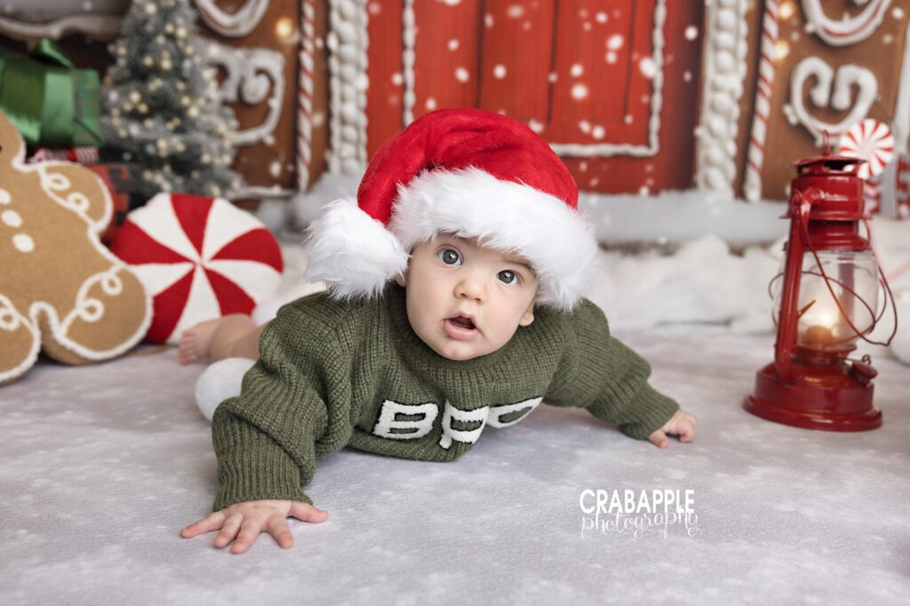 Baby boy smiling in green outfit with Santa hat