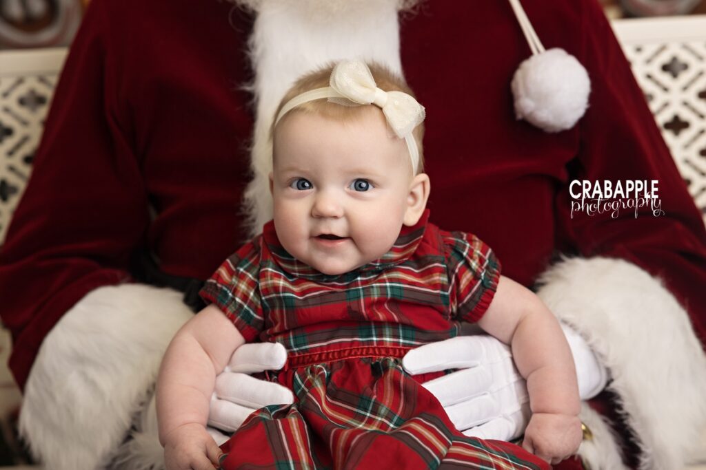 Close-up of infant with Santa for Christmas photo ornaments and gifts Close-up of an infant girl smiling in Santa’s arms, perfect for Santa photo gifts and Christmas photo ornaments.