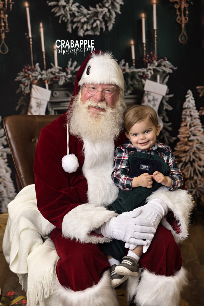 Toddler with Santa for holiday portrait gift ideas Toddler boy sitting on Santa’s lap during a festive session, ideal for holiday portrait gift ideas and Santa photo keepsakes.
