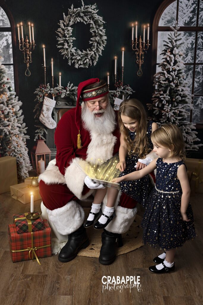 Santa reads a book with two sisters during Boston area holiday mini session