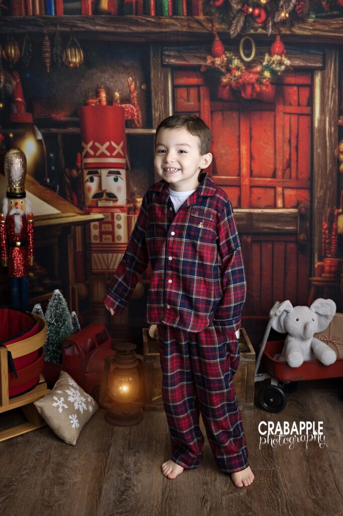 Toddler boy wearing plaid pajamas in a holiday studio portrait
