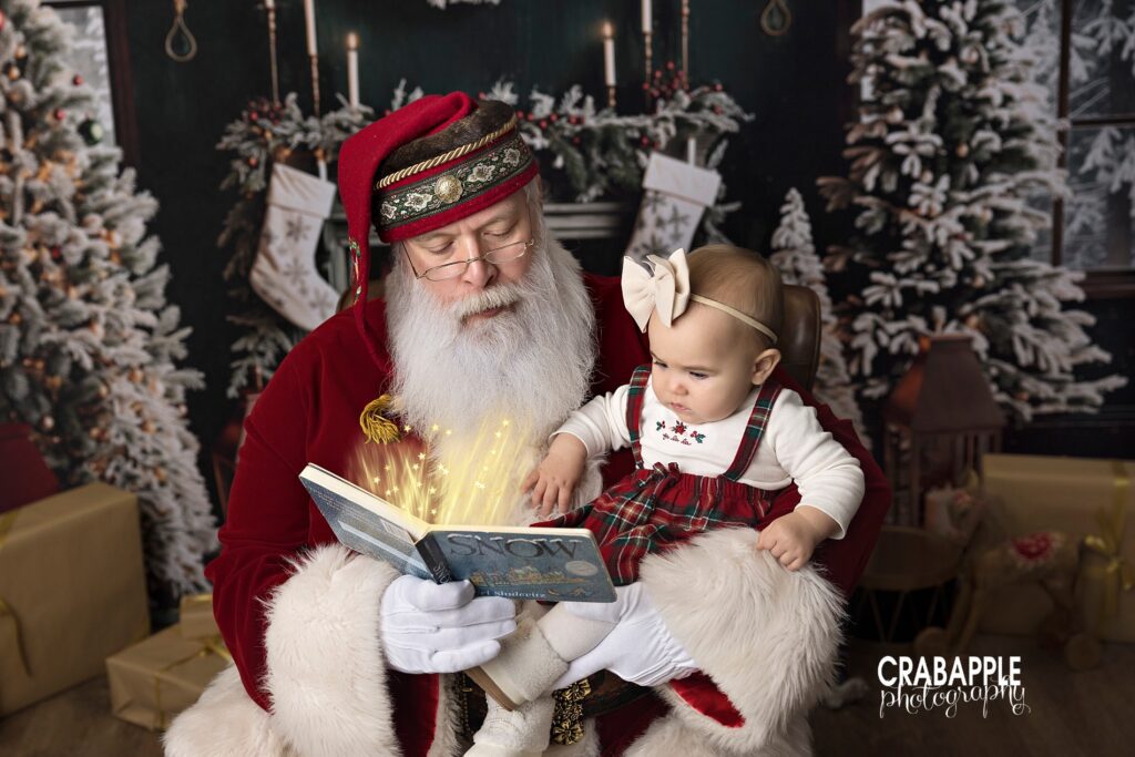 Santa reads a book to a baby girl during holiday mini session near Andover MA