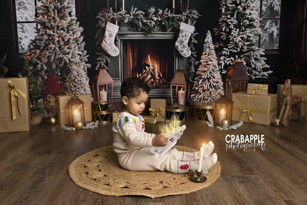 Toddler sitting and reading a book during a holiday studio session
