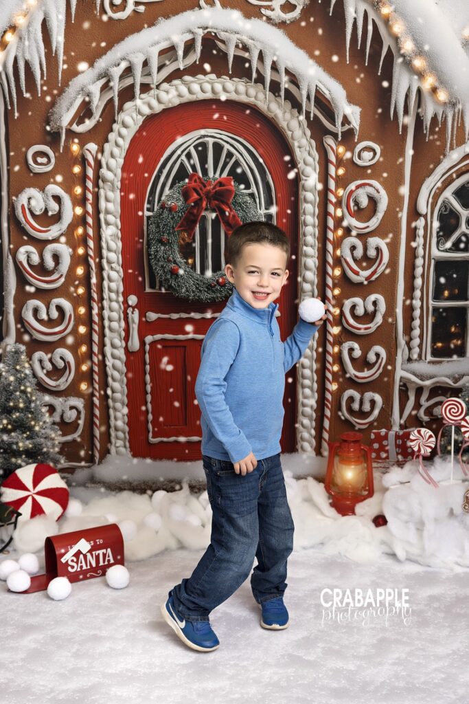 Young boy getting ready to throw a fake snowball in a holiday studio portrait
