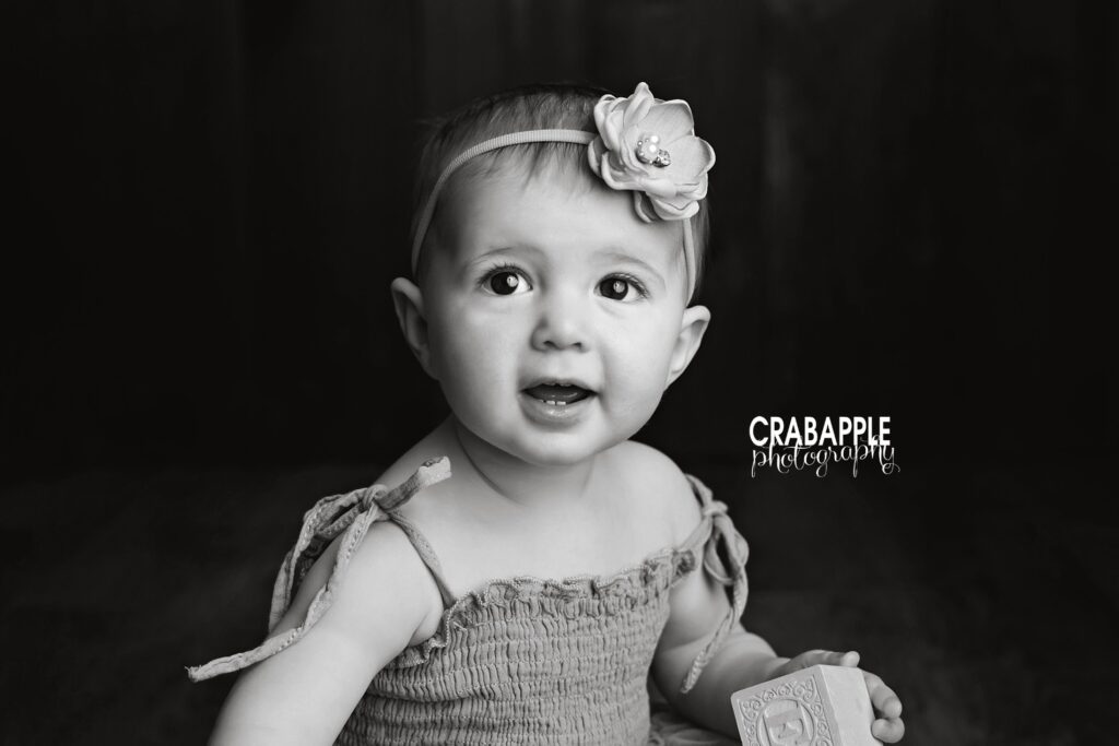 Classic baby pictures with timeless styling Classic baby pictures with dark wood floor and neutral tones in Andover MA photography studio