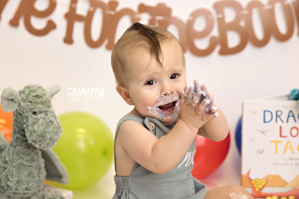 Color cake smash portrait of one-year-old boy
