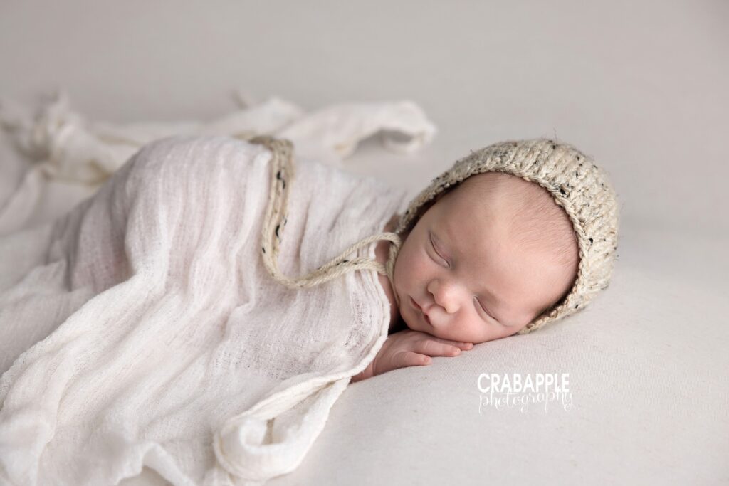 Cream neutral newborn baby photoshoot Newborn baby sleeping on a cream backdrop during a natural newborn baby photoshoot