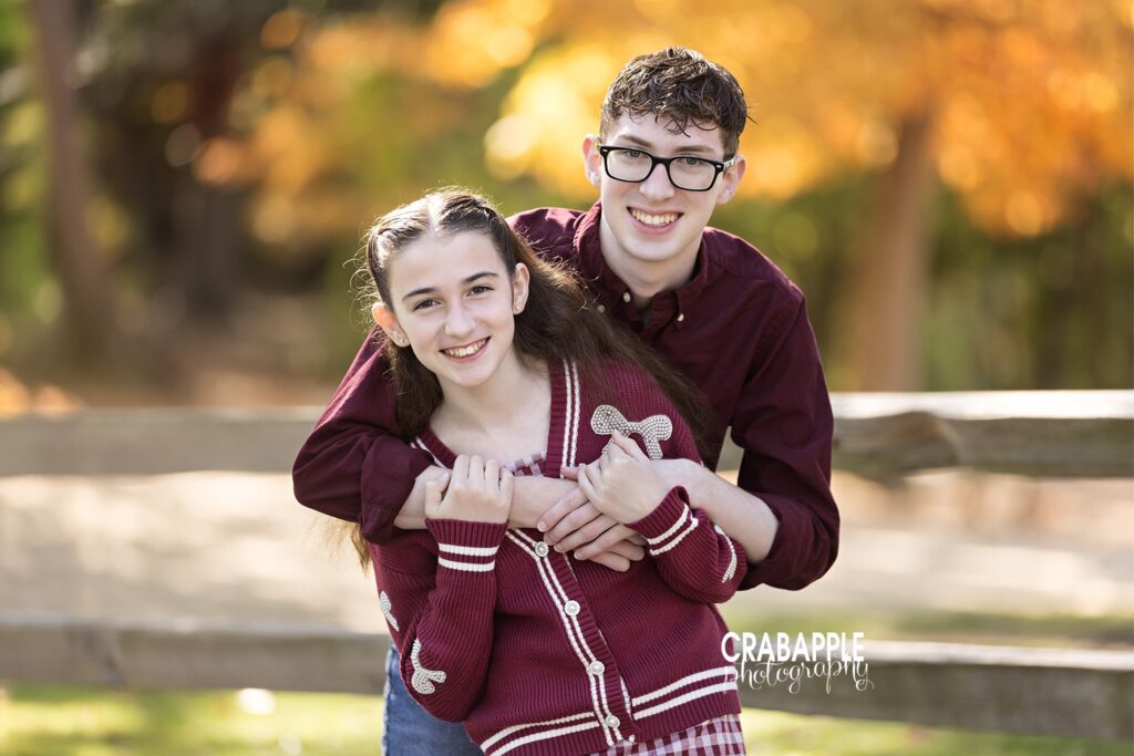 Siblings standing together during fall outdoor photo session

