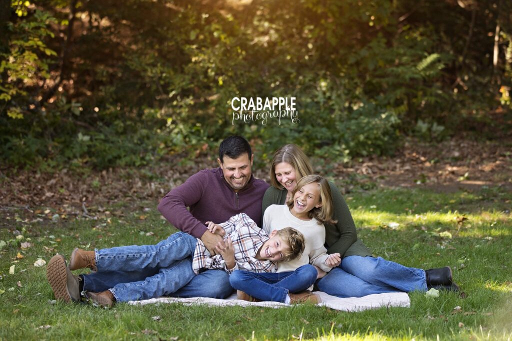 Outdoor family photo laughing and playing together
