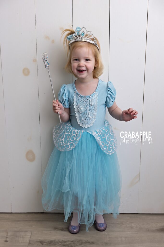 Joyful 3 year old girl smiling in a princess dress during a toddler photoshoot in Danvers MA studio
