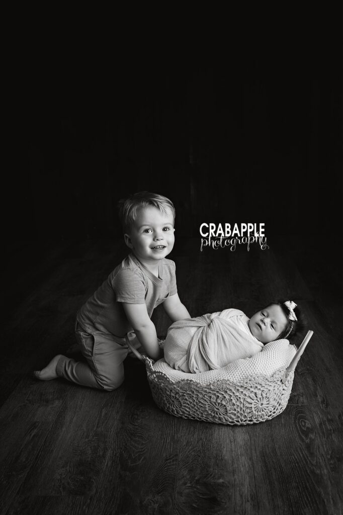 Timeless black and white newborn and sibling portrait capturing a quiet sibling bond

