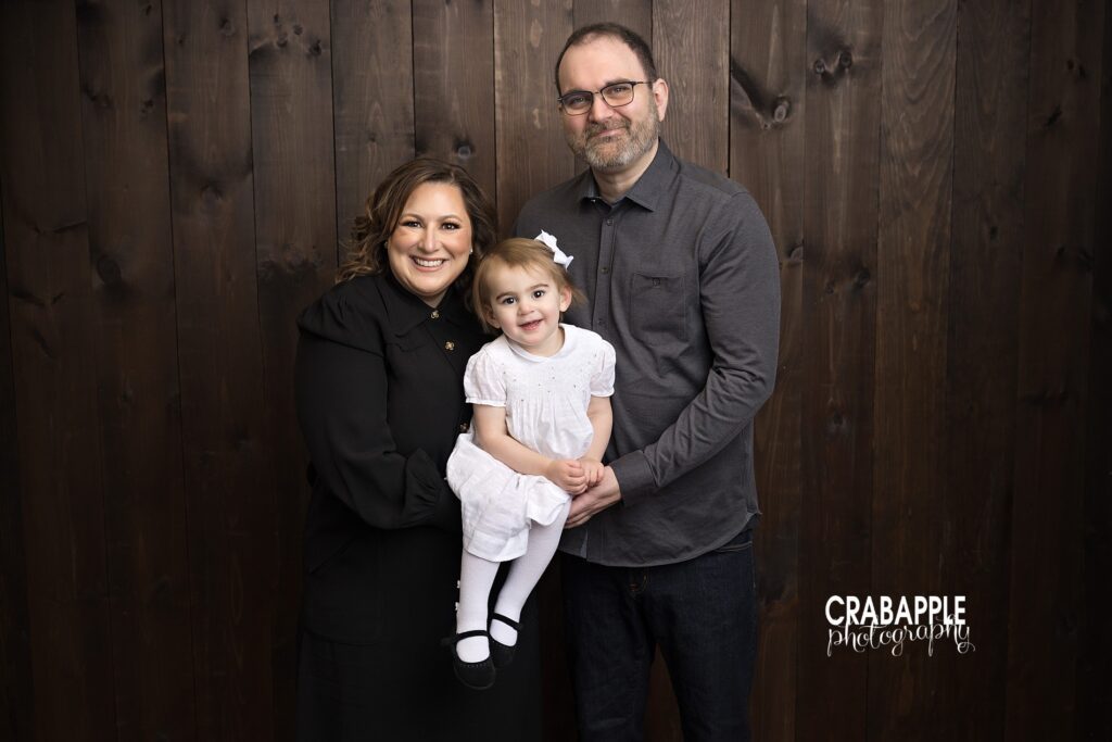 Two year old girl with both parents during a studio family portrait session in Andover MA

