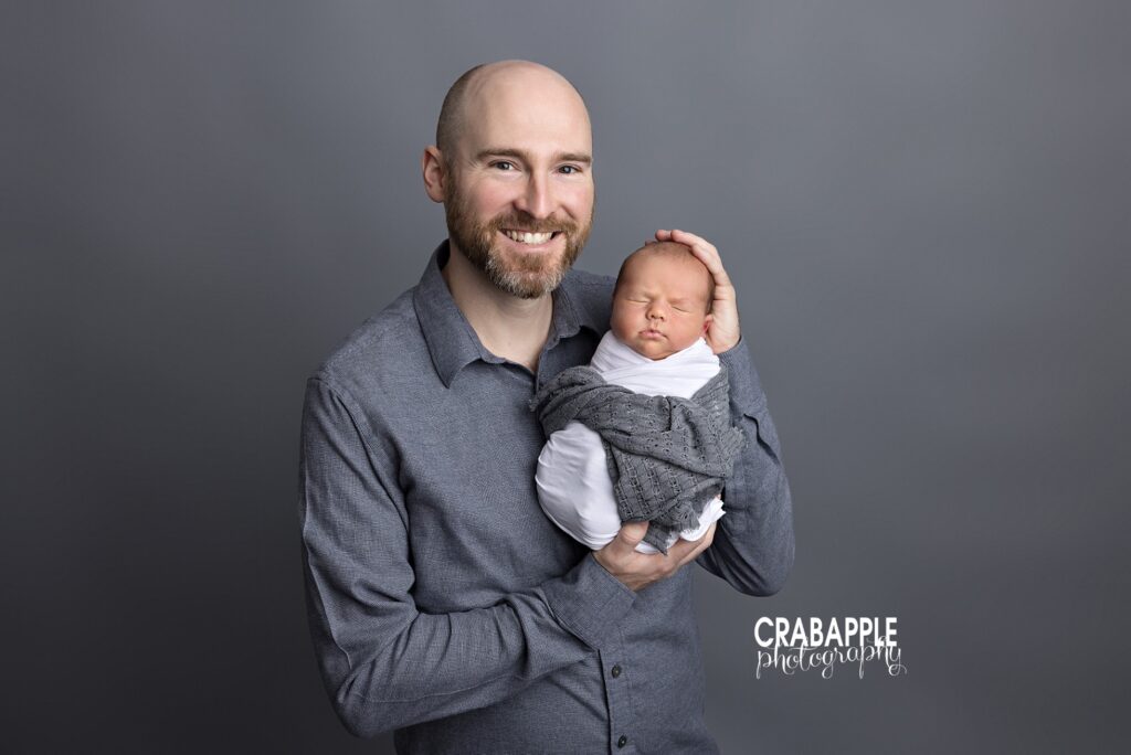Father holding newborn in simple, timeless studio portraits in Littleton MA
