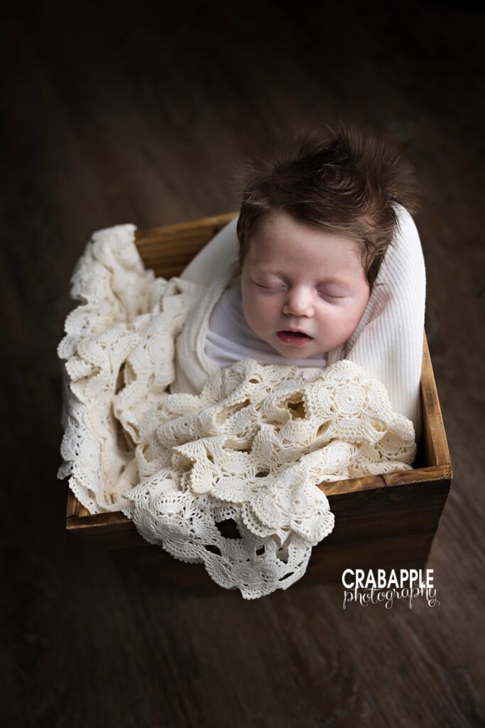 Timeless newborn portrait with neutral styling and organic textures

