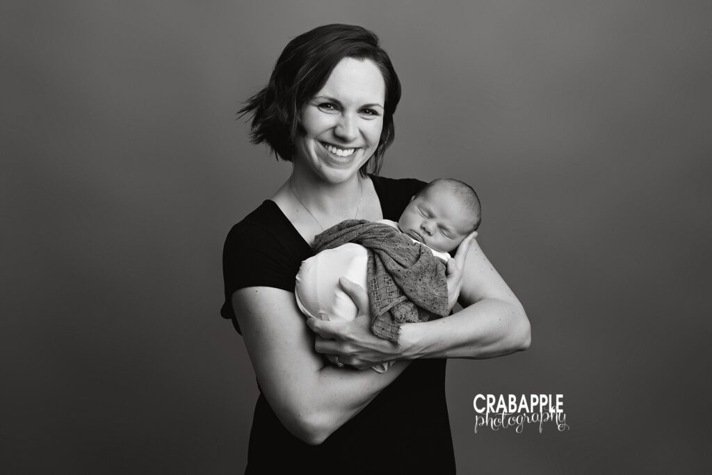 Mother holding her newborn during a calm studio session in Littleton MA
