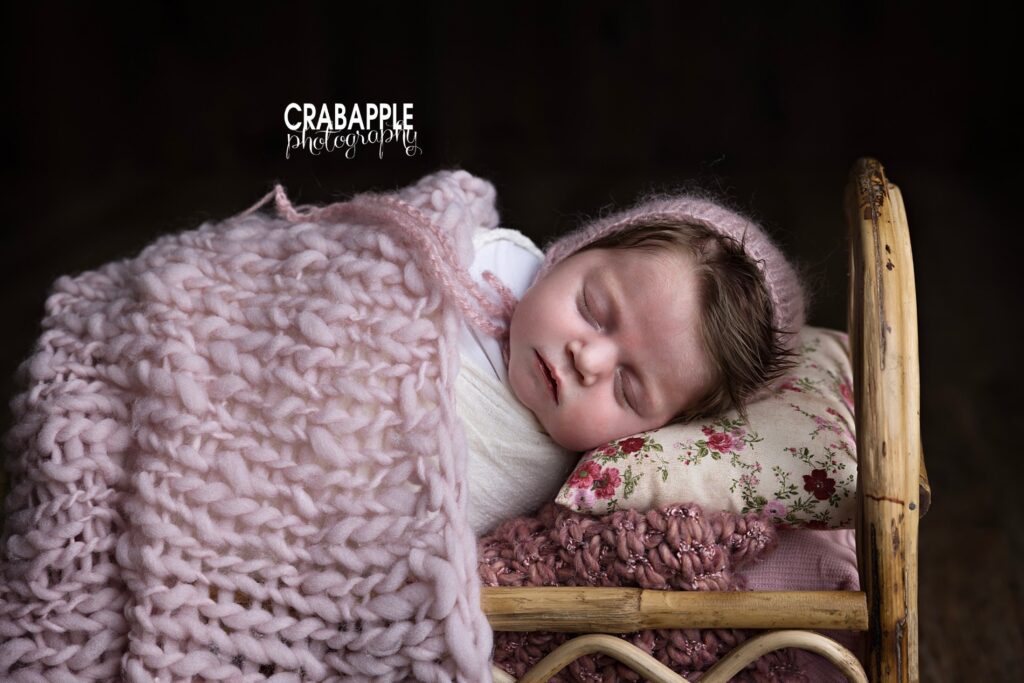 Styling inspiration for newborn photos using chunky knit blankets and wooden bed