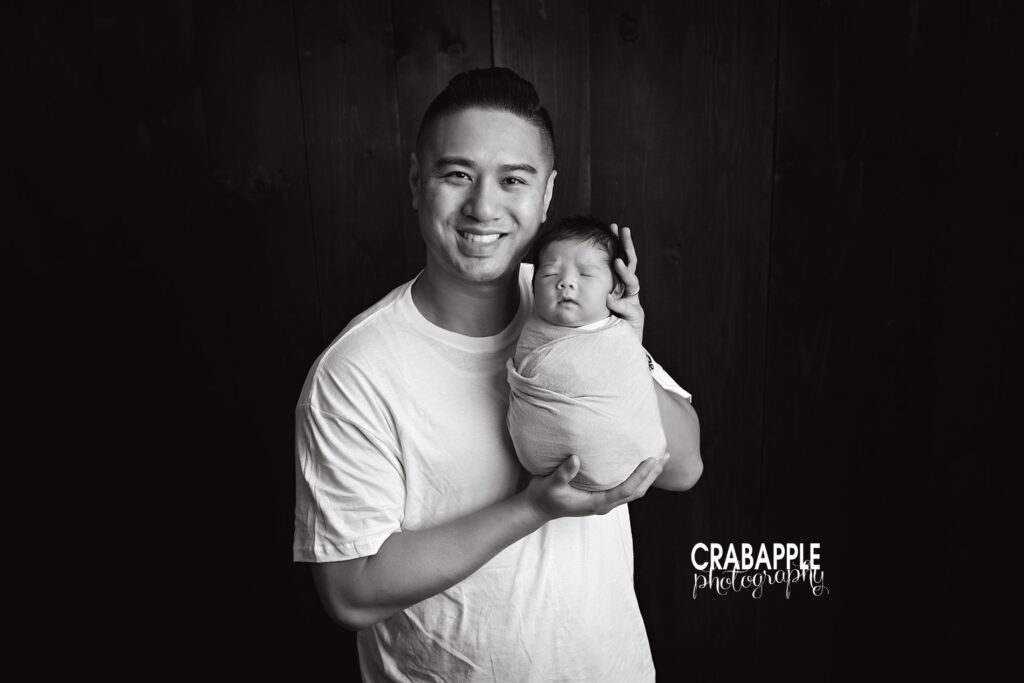 Father holding his newborn son during a Quincy MA studio newborn photoshoot
