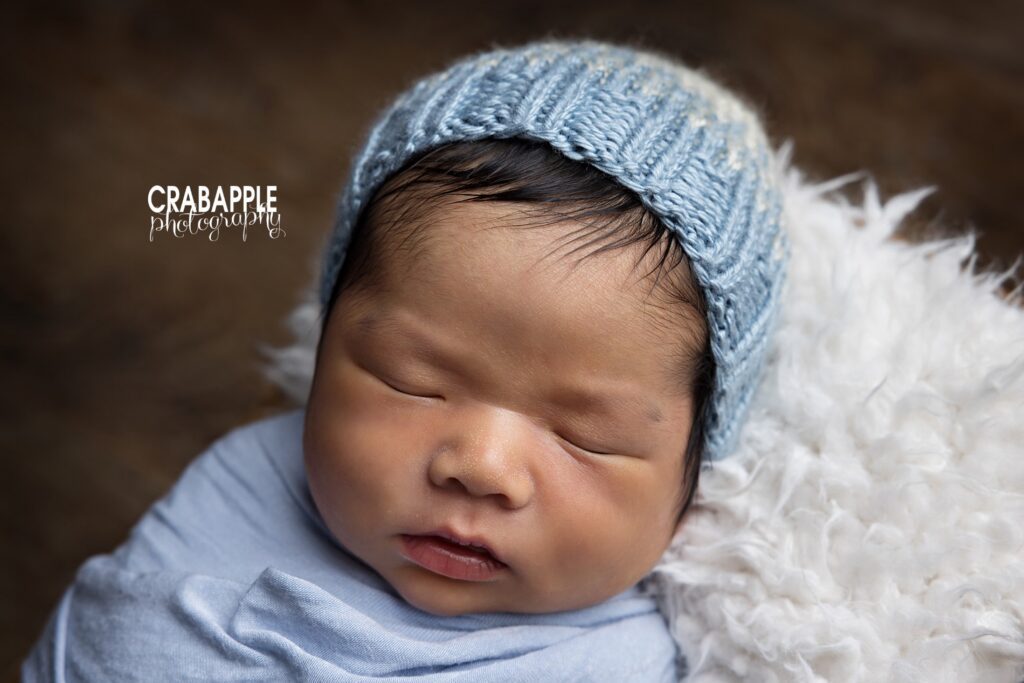 Sleeping newborn baby boy wearing a knit hat during a Quincy MA studio newborn photoshoot
