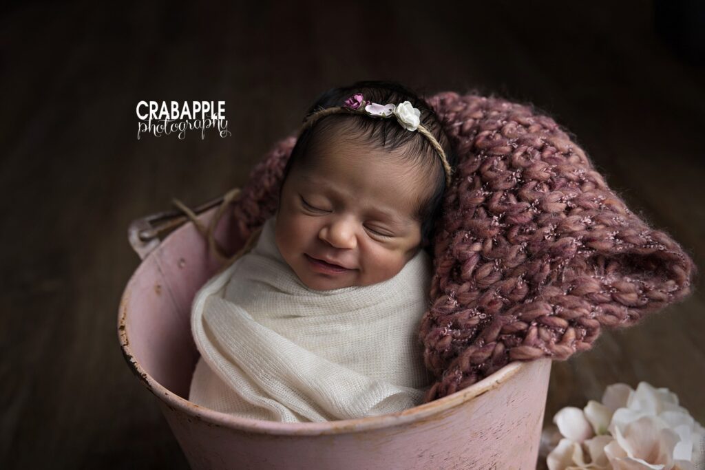 Newborn baby photos in Salem NH featuring a pink knit blanket and soft textures
