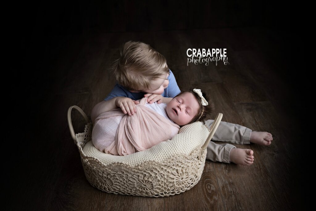 Sweet sibling moment with newborn and toddler brother during Ipswich MA newborn photography session
