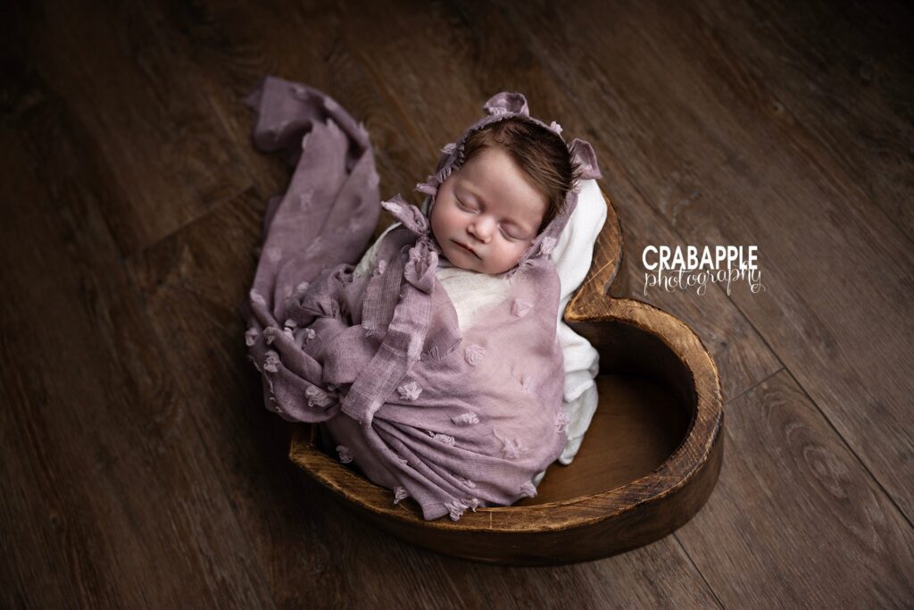 Newborn baby posed in wooden bowl prop during Ipswich MA newborn photography session
