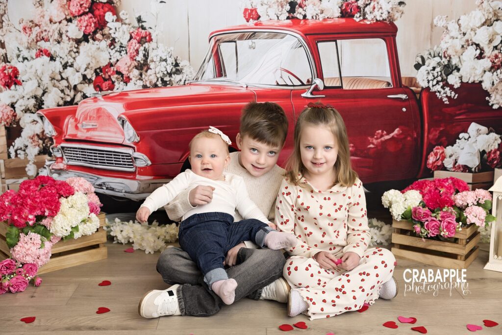 Children cuddled together for Valentine’s Day photos for kids with soft neutral styling