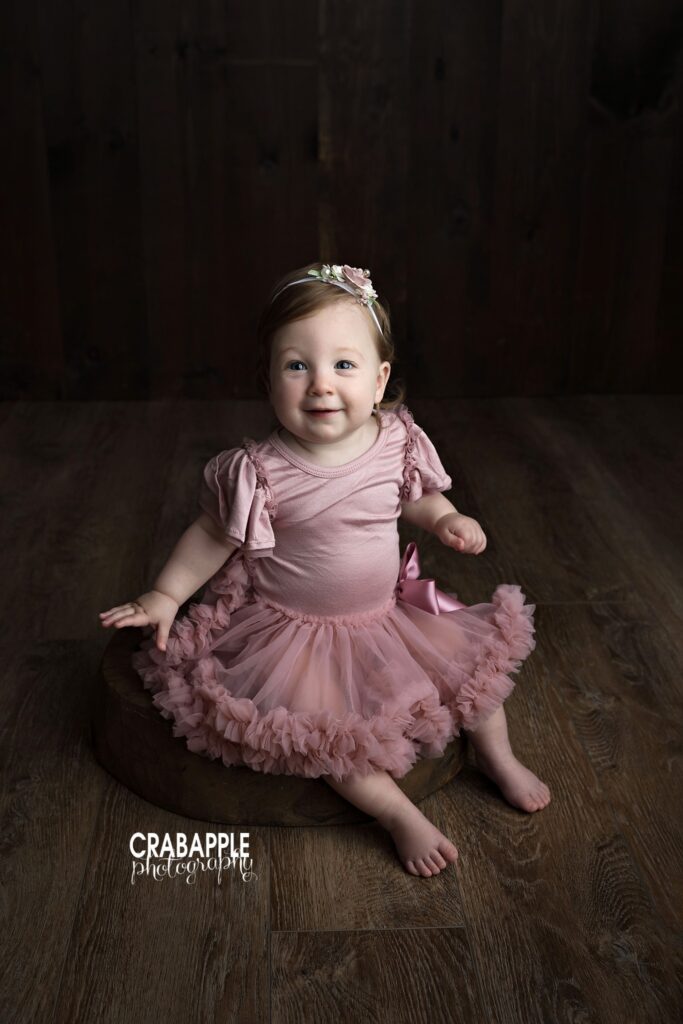 one year old girl portrait with dark backdrop

