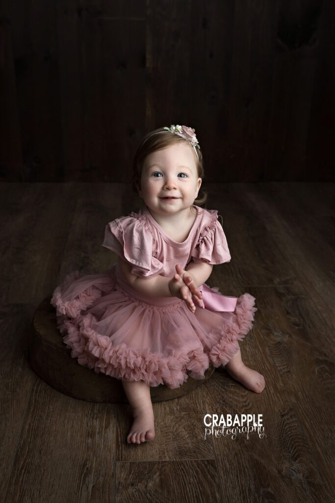 full body baby girl portrait with dark studio backdrop
