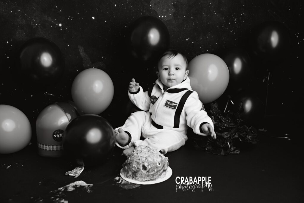 black and white photo of baby playing with cake during smash session
