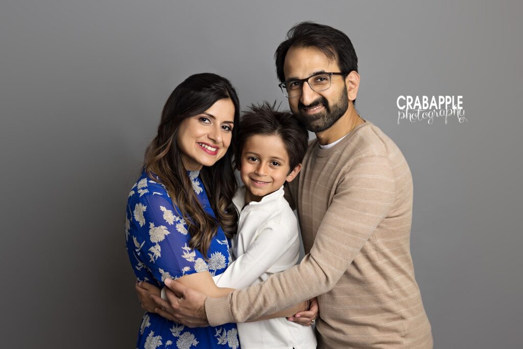 family cuddled together in studio with soft tones
