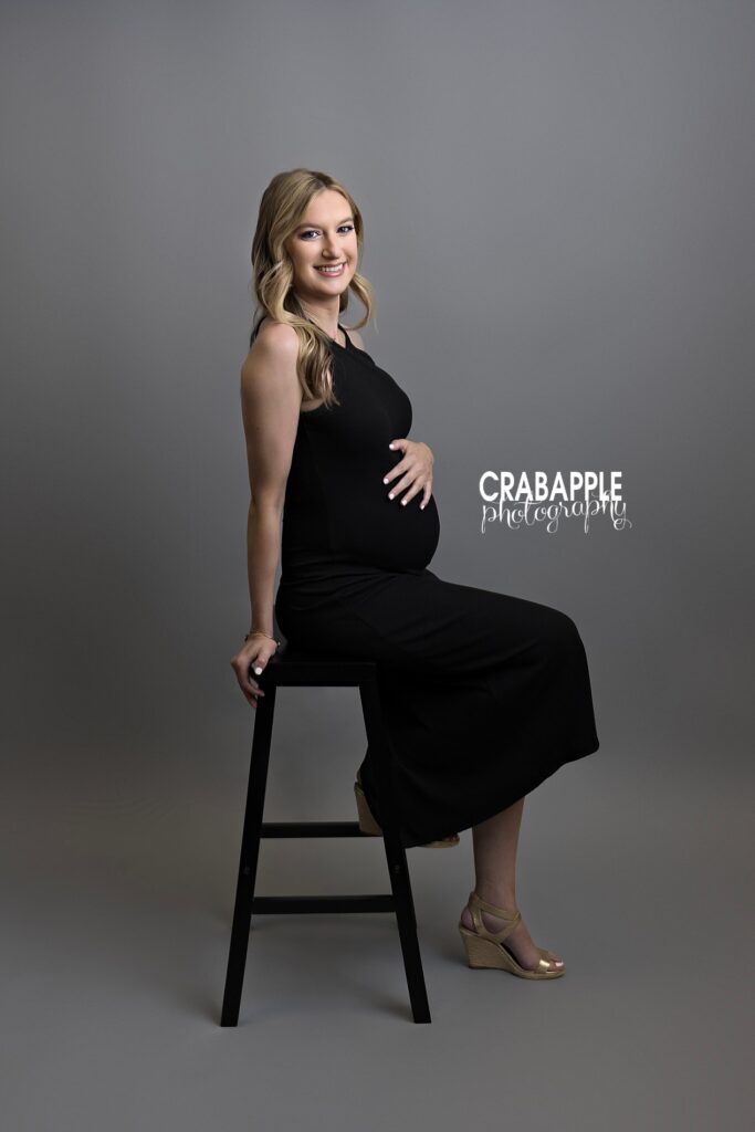 Elegant maternity photography Boston MA Upscale maternity photoshoot Boston featuring elegant black dress and soft studio lighting