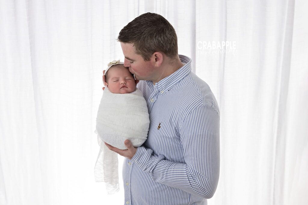 newborn photo ideas father holding newborn baby girl light airy family portrait North Andover MA
