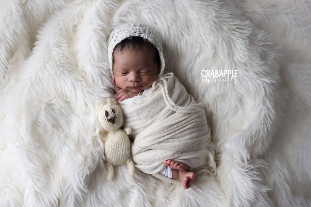 sleeping newborn wrapped in soft cream blanket
