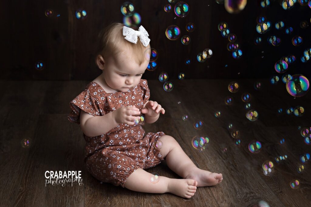 baby girl smiling at bubbles during studio session
