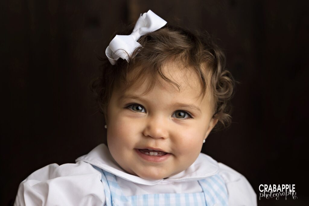 smiling baby girl wearing bow studio portrait by Southborough baby photographer