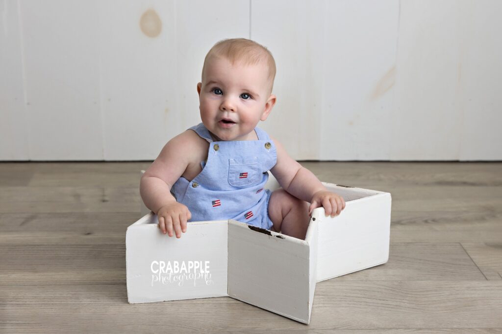 Star bowl prop baby sitting inside white wooden star bowl prop