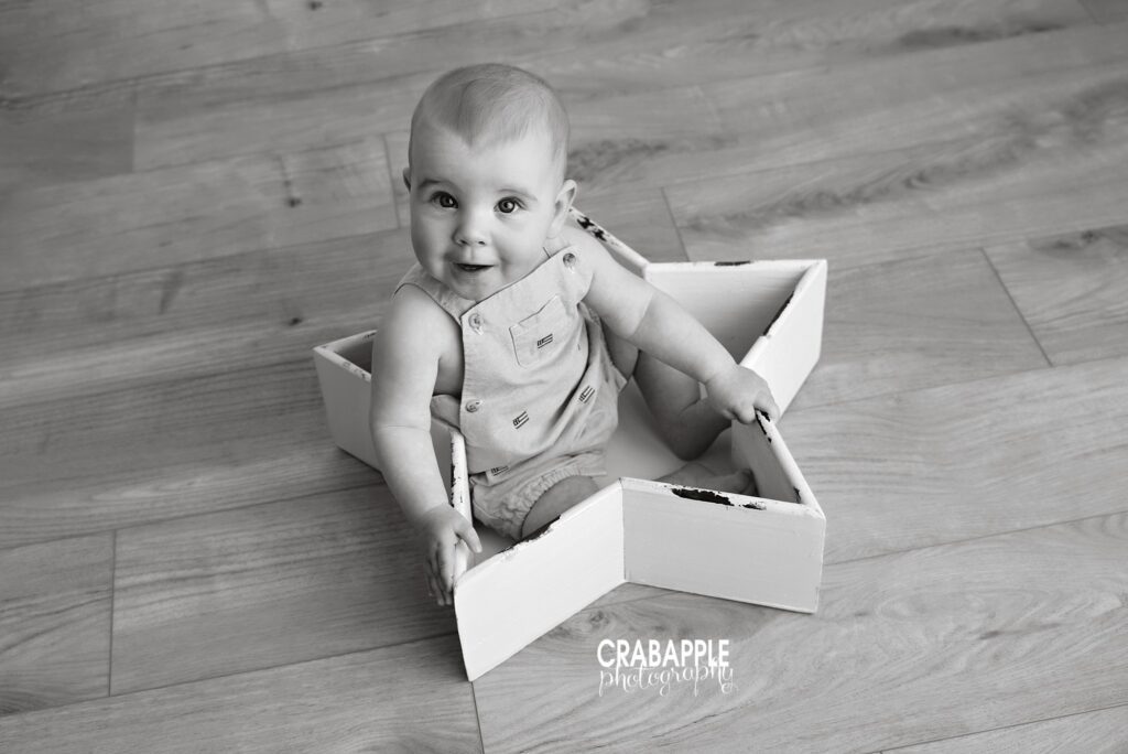 Star shaped box prop for baby photos Black and white photo of baby boy sitting inside white star shaped box prop smiling