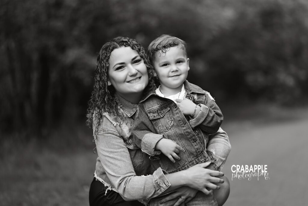 smiling mom and 3 year old boy hugging outdoors by a North Shore family photographer
