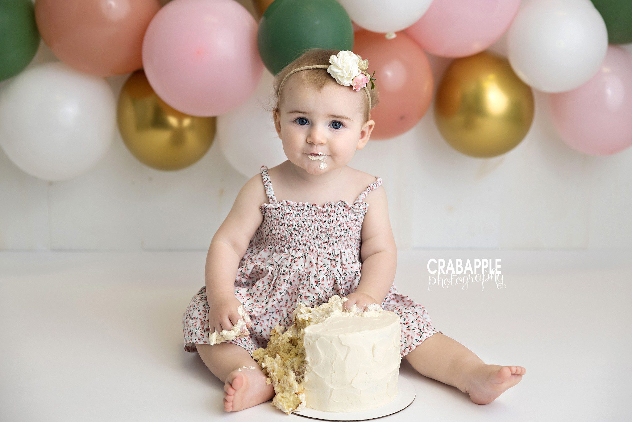 baby girl exploring cake during first birthday session

