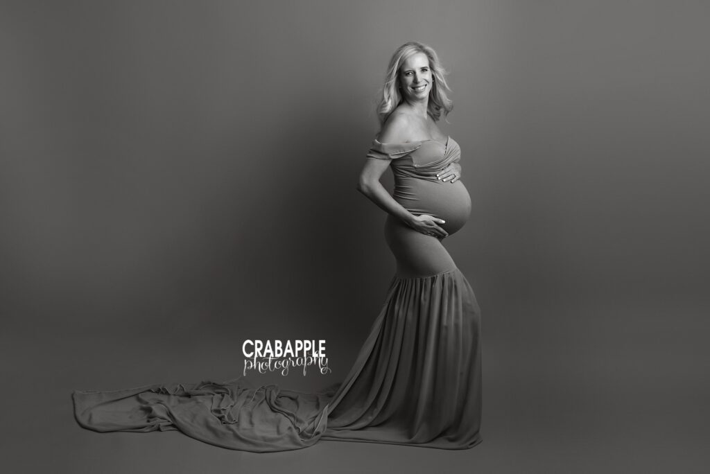 pregnant woman in dress with soft draping fabric in studio
