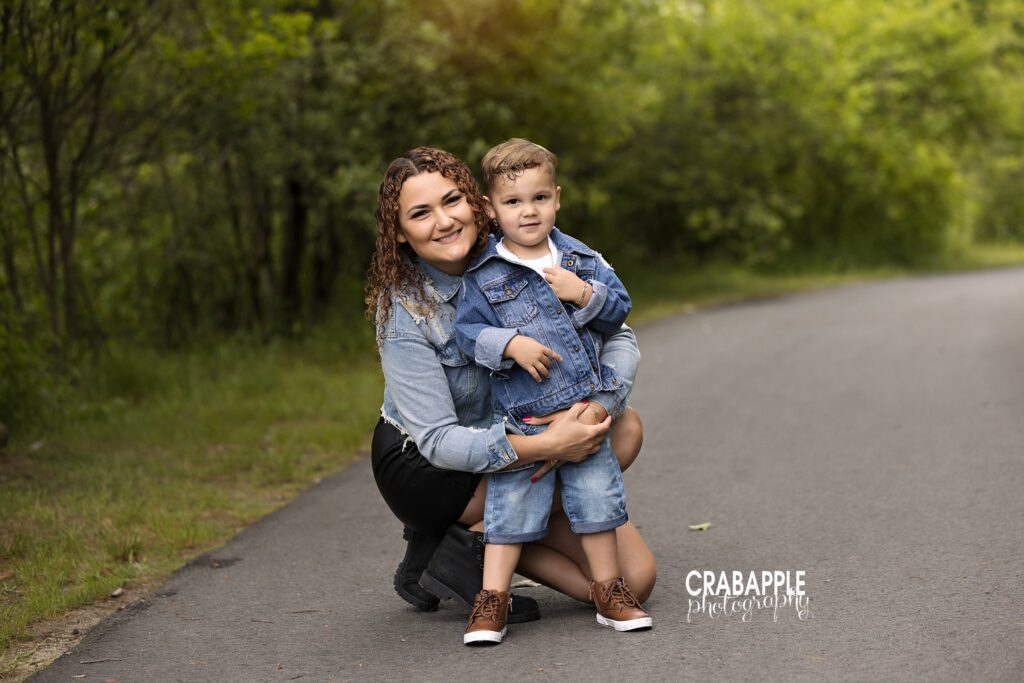 mom kneeling with 3 year old boy on path surrounded by greenery from a family photographer North Shore
