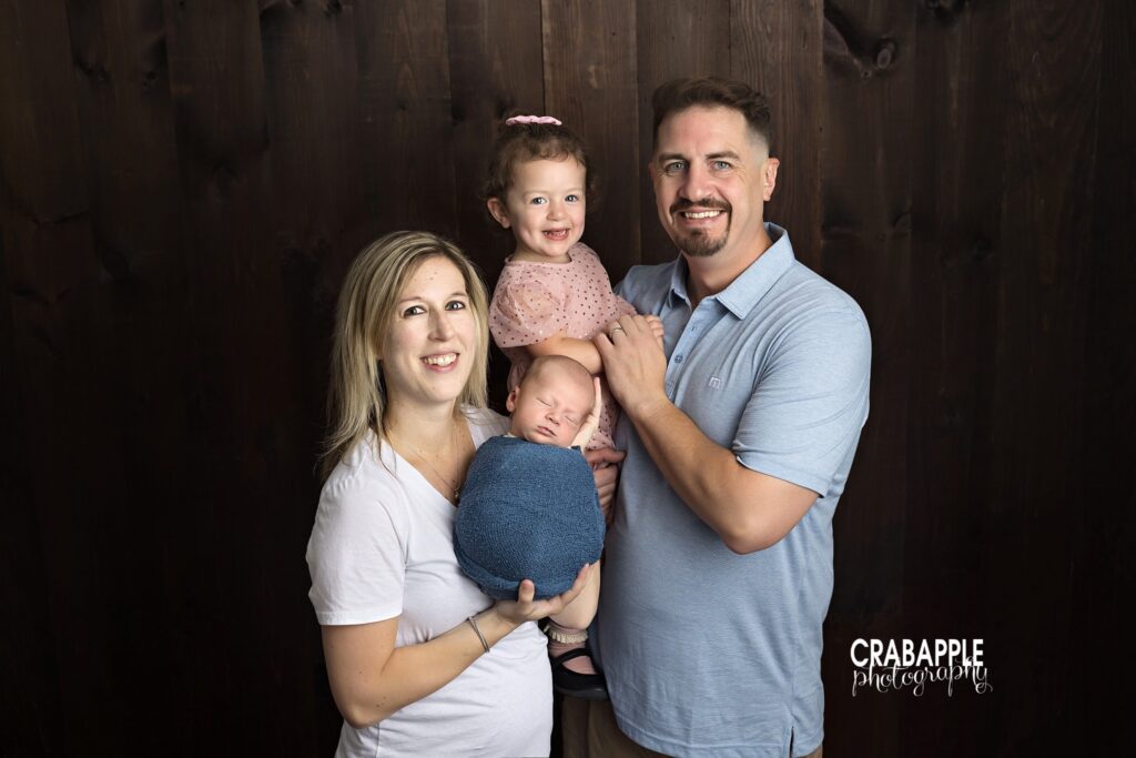 family portrait with newborn baby boy and parents in studio
