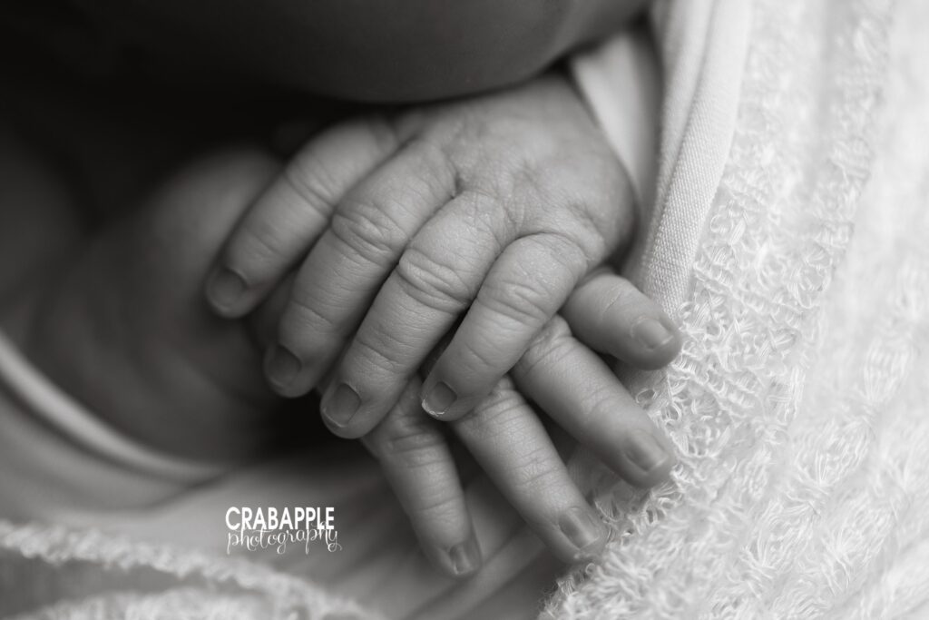 Close up detail photo of newborn hands in black and white