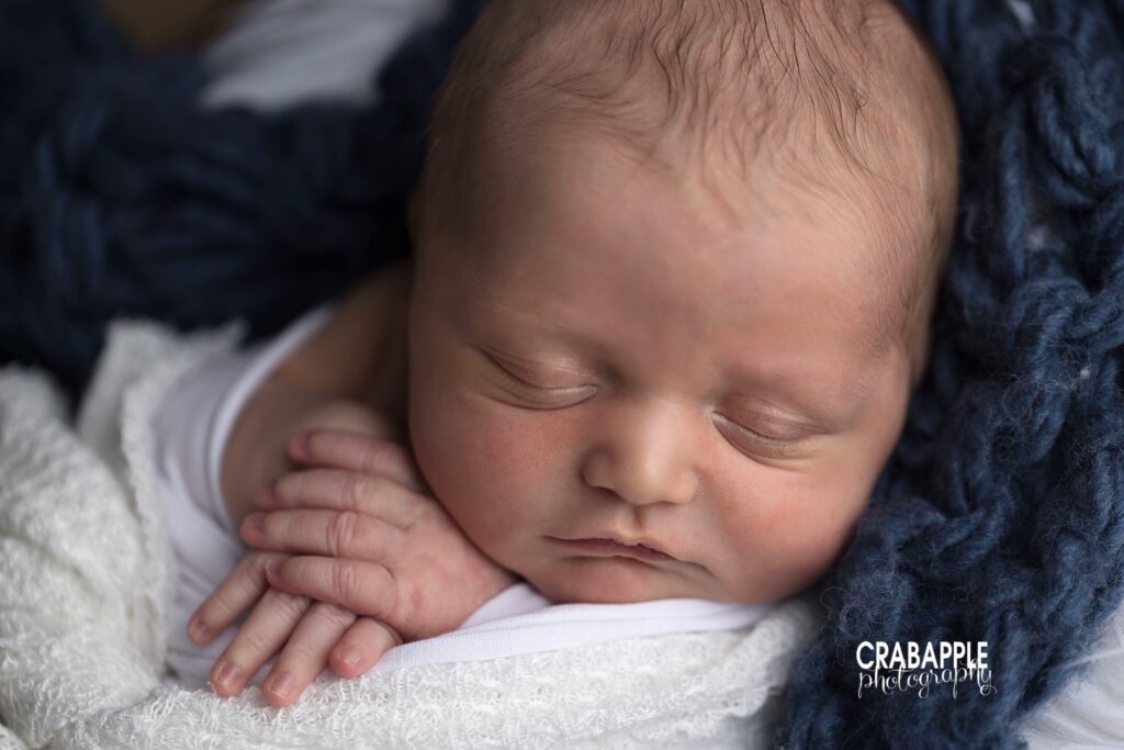 close up of newborn baby face and hands
