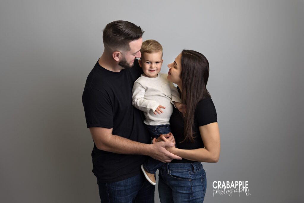 Mother and father holding toddler son during in studio family photos