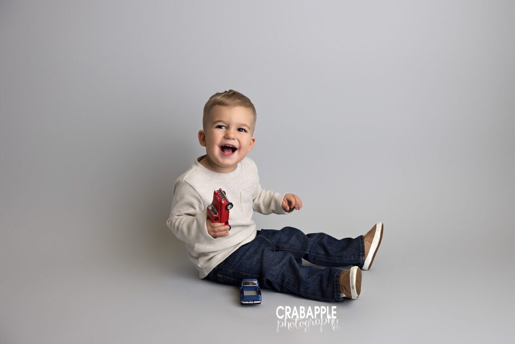 toddler playing with toy cars studio portrait
