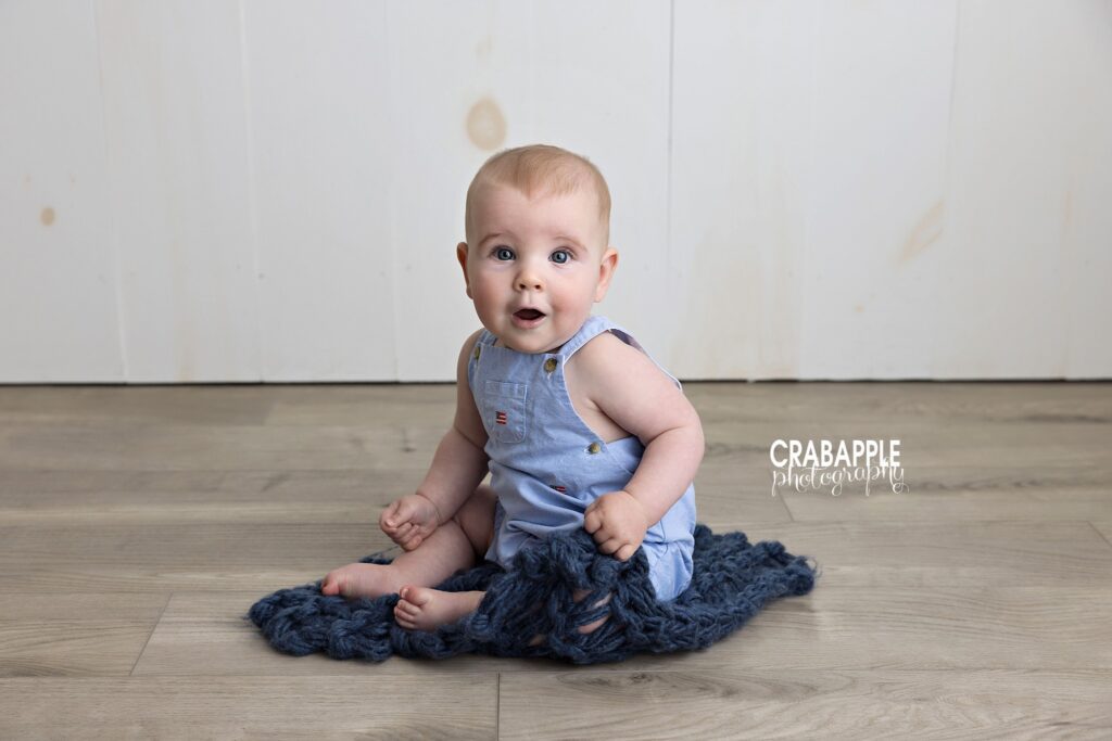 Simple milestone portrait 9 month baby sitting upright in simple studio setting