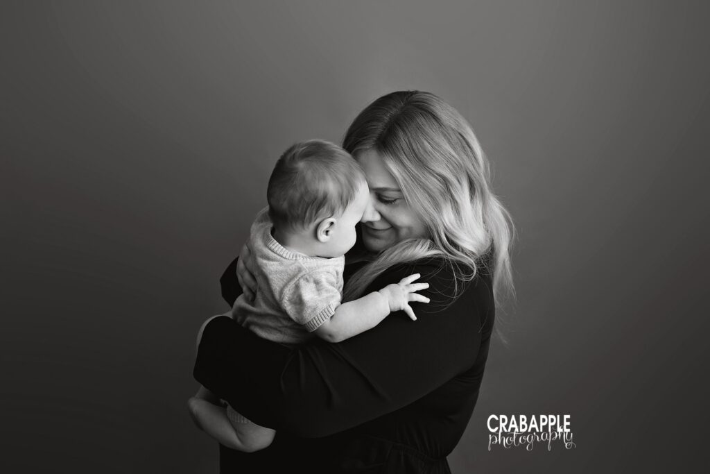 Mom and baby son share a sweet cuddle at baby photography studio near Amesbury