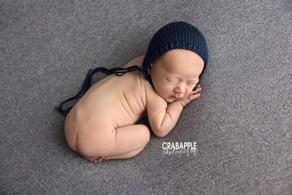 newborn baby boy lying on side wearing knit hat
