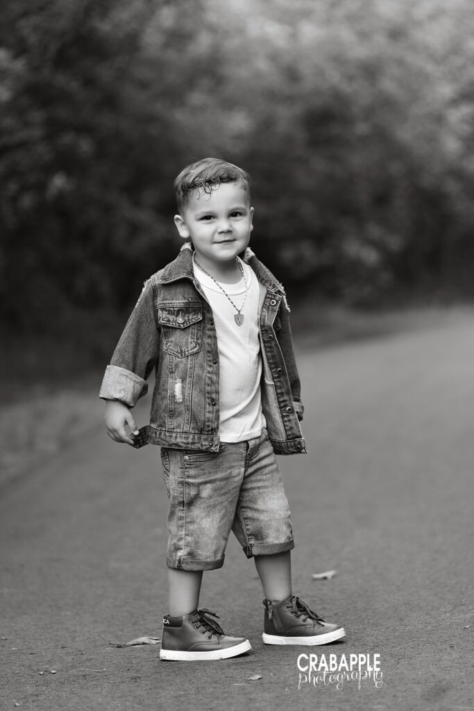 full body portrait of 3 year old boy standing on path during outdoor toddler photos
